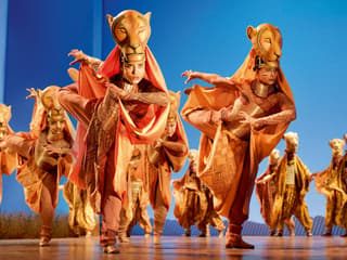 Performers in lion costumes on stage during The Lion King show in London