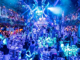 Guests enjoying Mamma Mia! The Party performance with vibrant lights and festive atmosphere