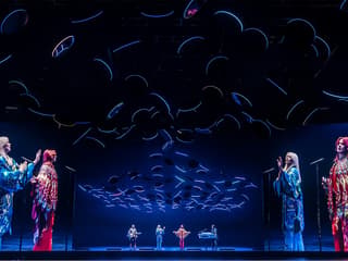 ABBA Voyage concert stage with holographic performers and dynamic lighting effects