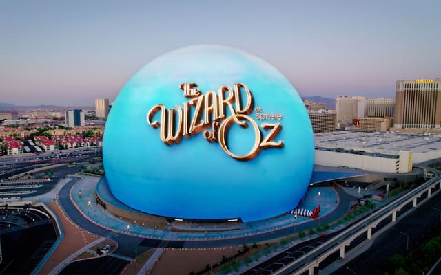 The Las Vegas Sphere lit up blue with The Wizard of Oz artwork above the Strip skyline at dusk