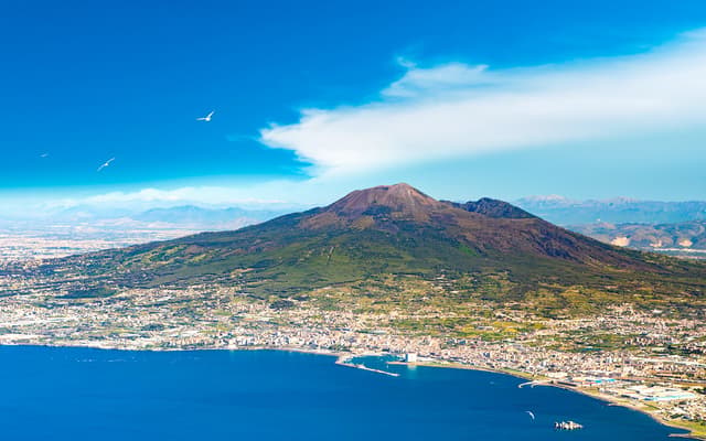 Mount Vesuvius rising over the Bay of Naples and coastal town near Herculaneum and Pompeii