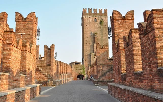Medieval brick Castelvecchio bridge and tower in Verona, Italy, lit by warm evening sunlight