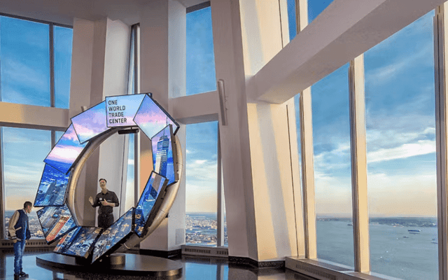 Inside One World Observatory with floor-to-ceiling windows over the New York skyline