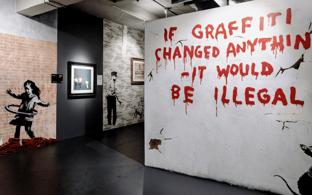 Banksy Museum gallery in New York with the If Graffiti Changed Anything mural and hula-hoop girl