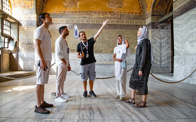 Tour guide pointing out gold mosaics to visitors inside the Hagia Sophia in Istanbul