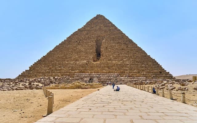 Pyramid of Giza seen from a paved walkway under a clear blue sky near Cairo