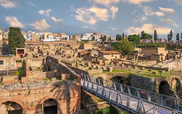 Excavated Roman ruins of Herculaneum with the modern town and blue sky behind