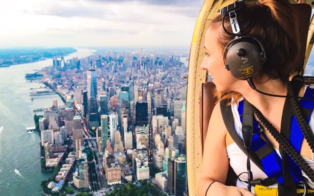 Woman in a helicopter looking out over the Manhattan skyline and Hudson River