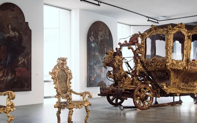 Sicilian museum gallery in Messina with a gilded baroque carriage and ornate golden chairs