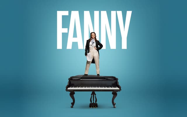 Performer standing on a grand piano in London theater.