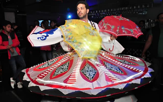 Tanoura whirling dancer in a bright spinning skirt performing at an evening show in Cairo
