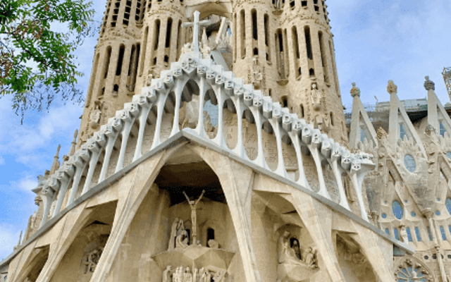 The Sagrada Familia basilica facade and spires under a blue sky in Barcelona