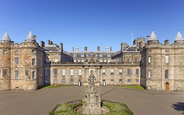 Palace of Holyroodhouse in Edinburgh under a clear blue sky, royal residence and front courtyard