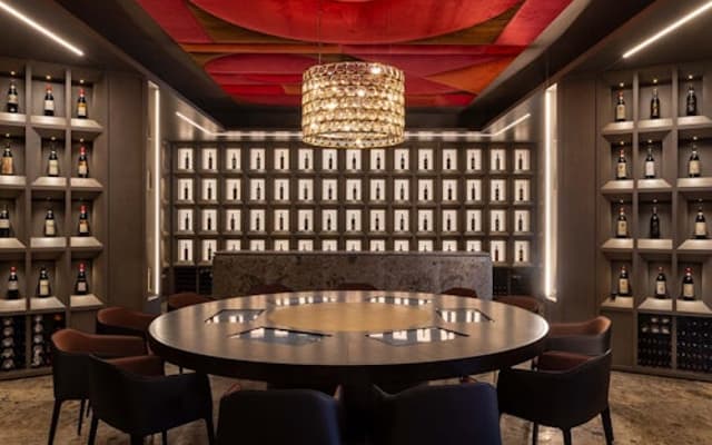 Elegant Montalcino wine-tasting room with a round table and Brunello bottles lining the walls