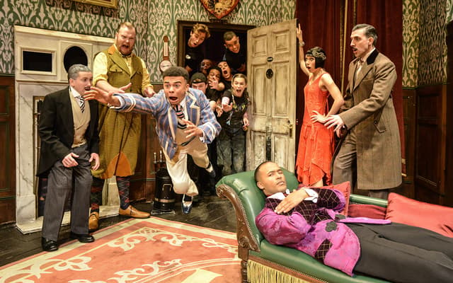 The cast of The Play That Goes Wrong amid a collapsing stage set