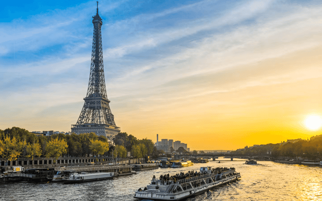 Paris Seine river at night with the illuminated Eiffel Tower in the background