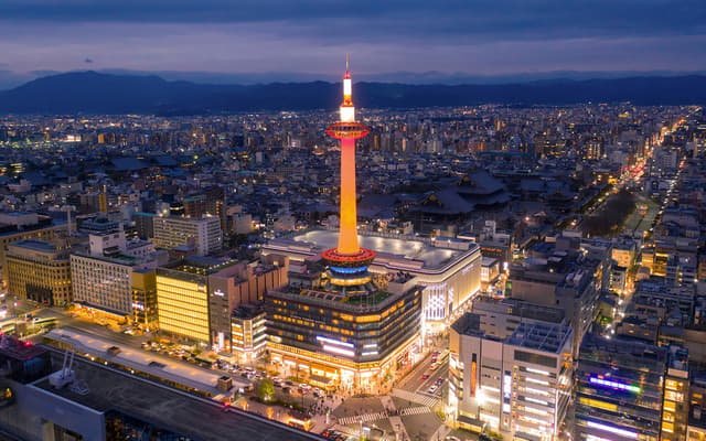Kyoto Tower lit up at night above the city