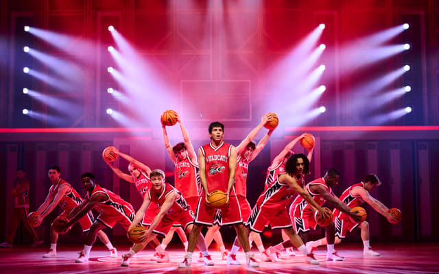 Tobias Turley as Troy Bolton and the company in the basketball number in High School Musical