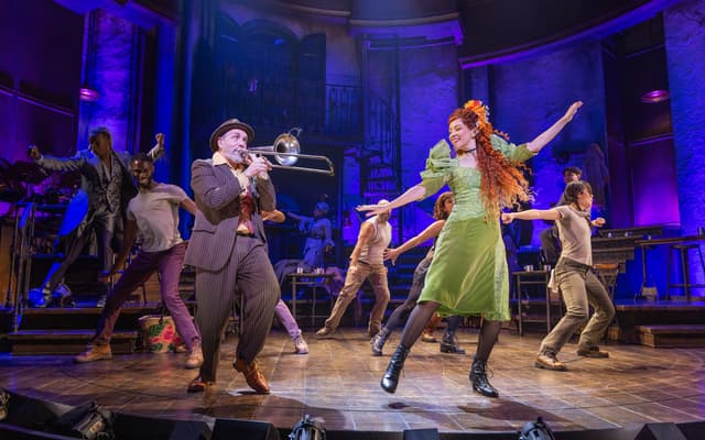 The company of Hadestown performing a dance number on the revolving stage on Broadway