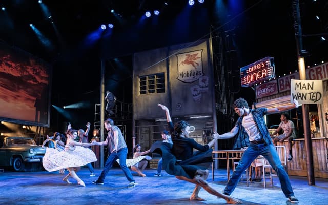 The company of Matthew Bourne's The Car Man dancing on the garage-diner set at Sadler's Wells. Photo by Johan Persson