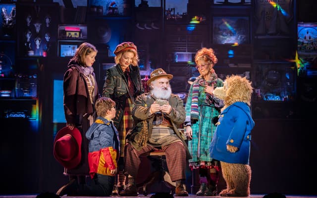 Paddington with the Brown family and Mr Gruber on stage in Paddington The Musical at the Savoy Theatre