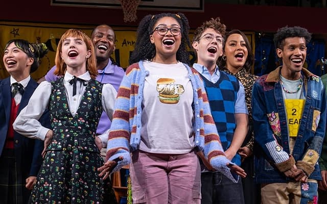 The full company on stage under the Putnam County Spelling Bee banner at New World Stages in New York