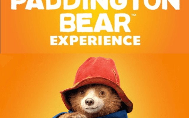 The Paddington Bear Experience poster, Paddington in a red hat and blue coat holding marmalade sandwiches