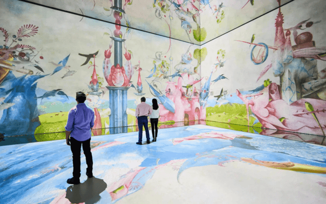 Visitors inside Frameless London immersive digital art room with surreal painted walls
