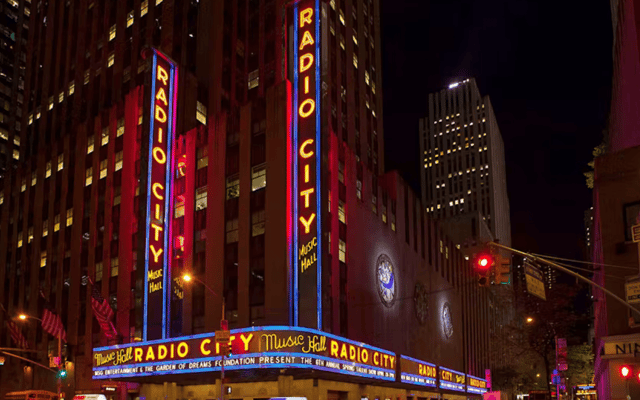 Radio City Music Hall neon marquee lit up red and blue at night in New York