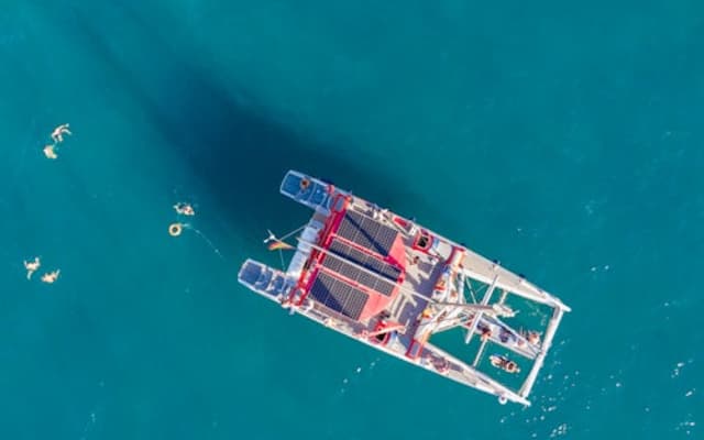Aerial view of a catamaran and swimmers in turquoise sea off Costa Adeje, Tenerife
