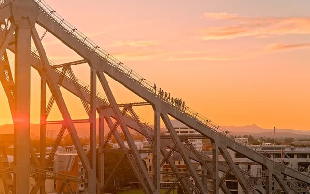 Climbers on the Story Bridge Adventure Climb above Brisbane at golden sunset