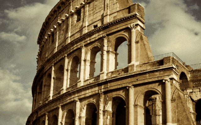 The Colosseum's ancient stone arches lit by warm evening light in Rome, Italy