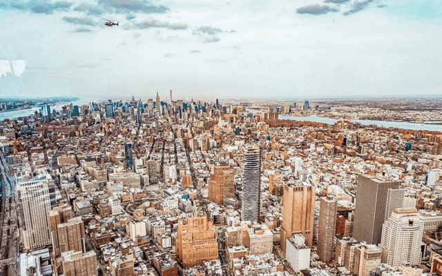 Aerial daytime view of the Manhattan skyline with a helicopter over New York City