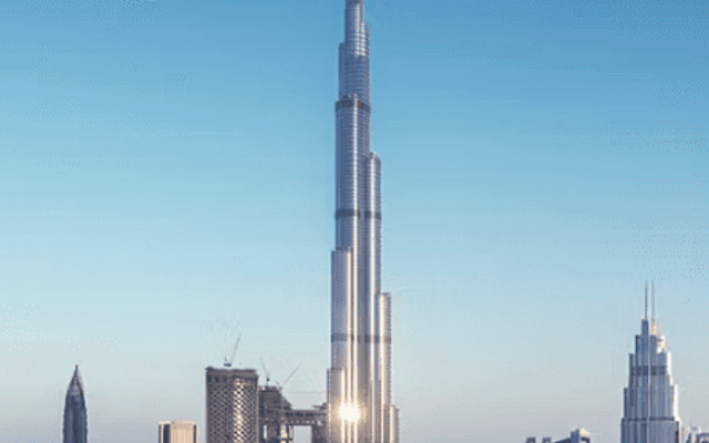 Burj Khalifa towering over the downtown Dubai skyline under a clear blue daytime sky