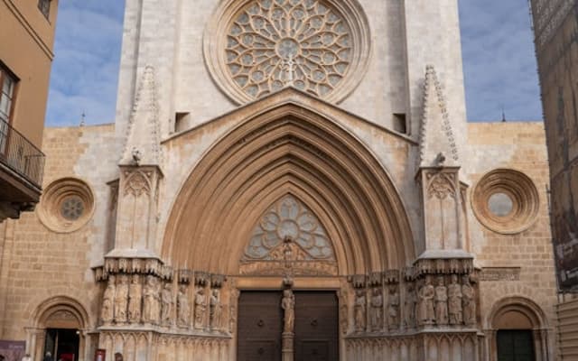 Gothic stone facade and rose window of Tarragona Cathedral in a quiet plaza