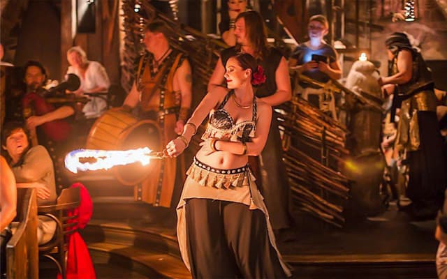 Fire performer with a flaming torch at an immersive medieval dinner show in Prague