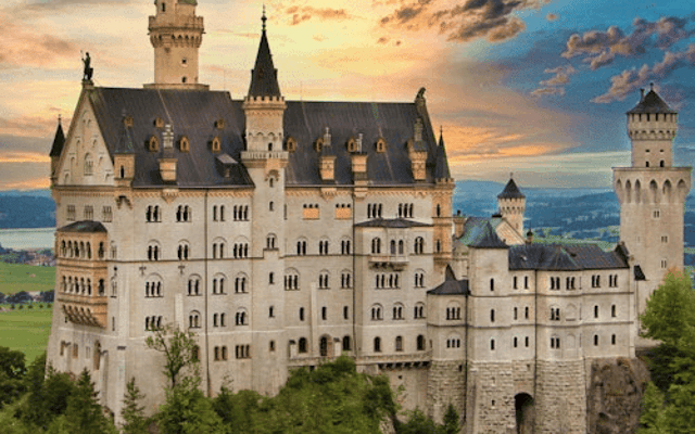 Neuschwanstein Castle on a wooded hilltop at sunset near Schwangau, Bavaria