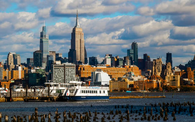 Midtown Manhattan skyline with the Empire State Building and a ferry on the Hudson River