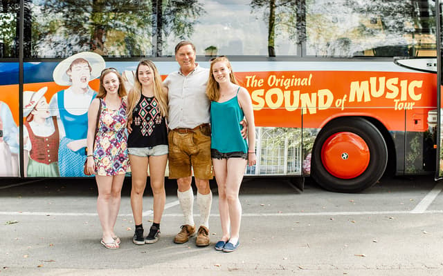 Family posing by the Original Sound of Music tour bus in Salzburg, Austria