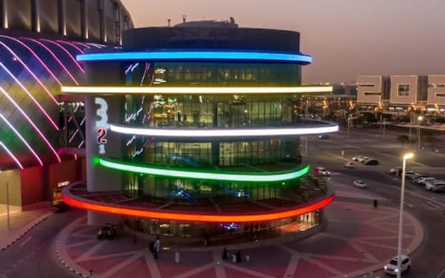 Illuminated 3-2-1 Qatar Olympic and Sports Museum lit in colour at dusk in Doha