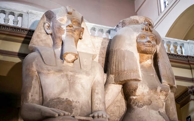 Colossal ancient Egyptian pharaoh statues on display in a Cairo museum hall