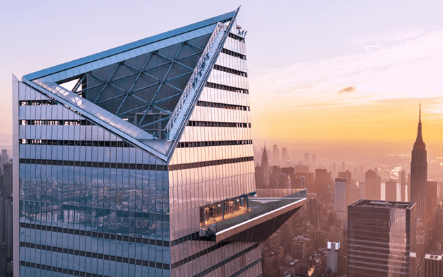 Edge observation deck triangular glass platform above the New York skyline at sunset