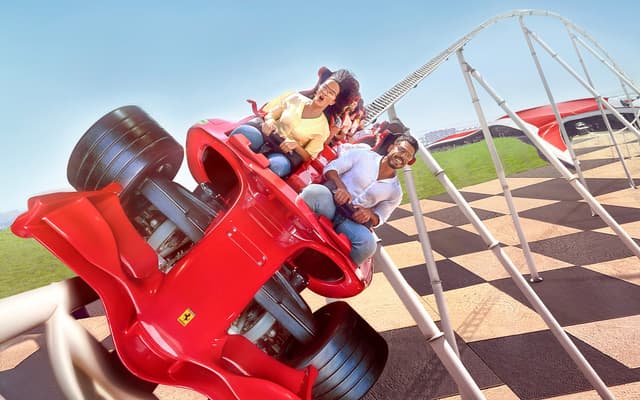 Riders laughing on the red Ferrari World roller coaster in Abu Dhabi