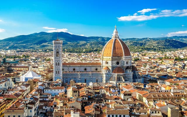 Florence skyline with the Duomo's terracotta dome and Giotto's bell tower above Tuscan rooftops