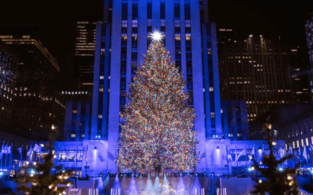 Rockefeller Center Christmas tree lit at night above the ice rink in New York City