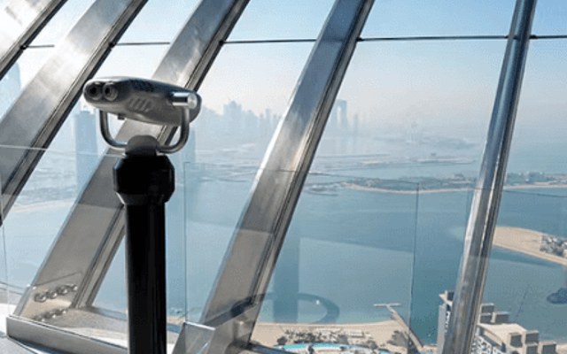Rooftop viewing telescope on a Dubai observation deck overlooking Palm Jumeirah and the sea