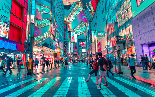 people walking on road near well-lit buildings