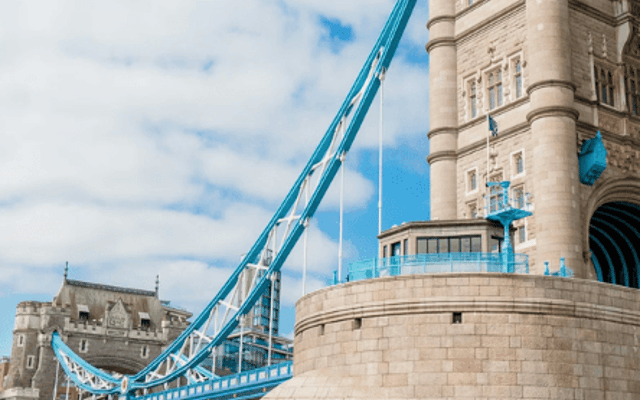 A red Thames Rockets speedboat racing past Tower Bridge with passengers on the River Thames in London