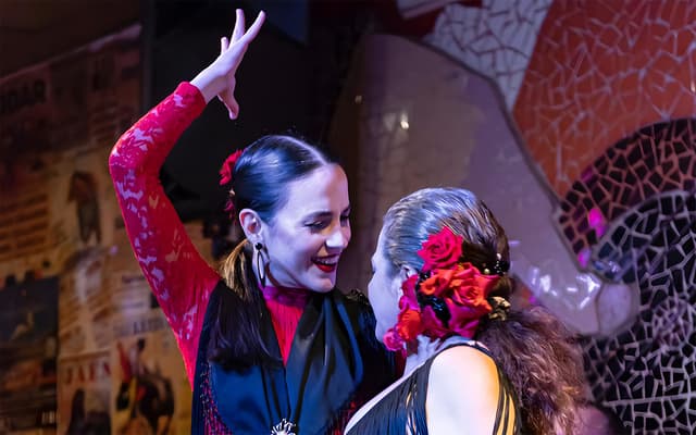 Two flamenco dancers in red and black performing at night in Valencia