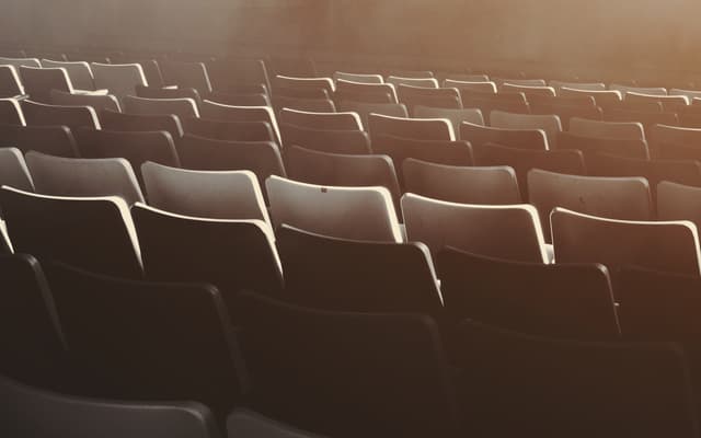 Rows of empty theatre seats in warm hazy light, Broadway auditorium in New York